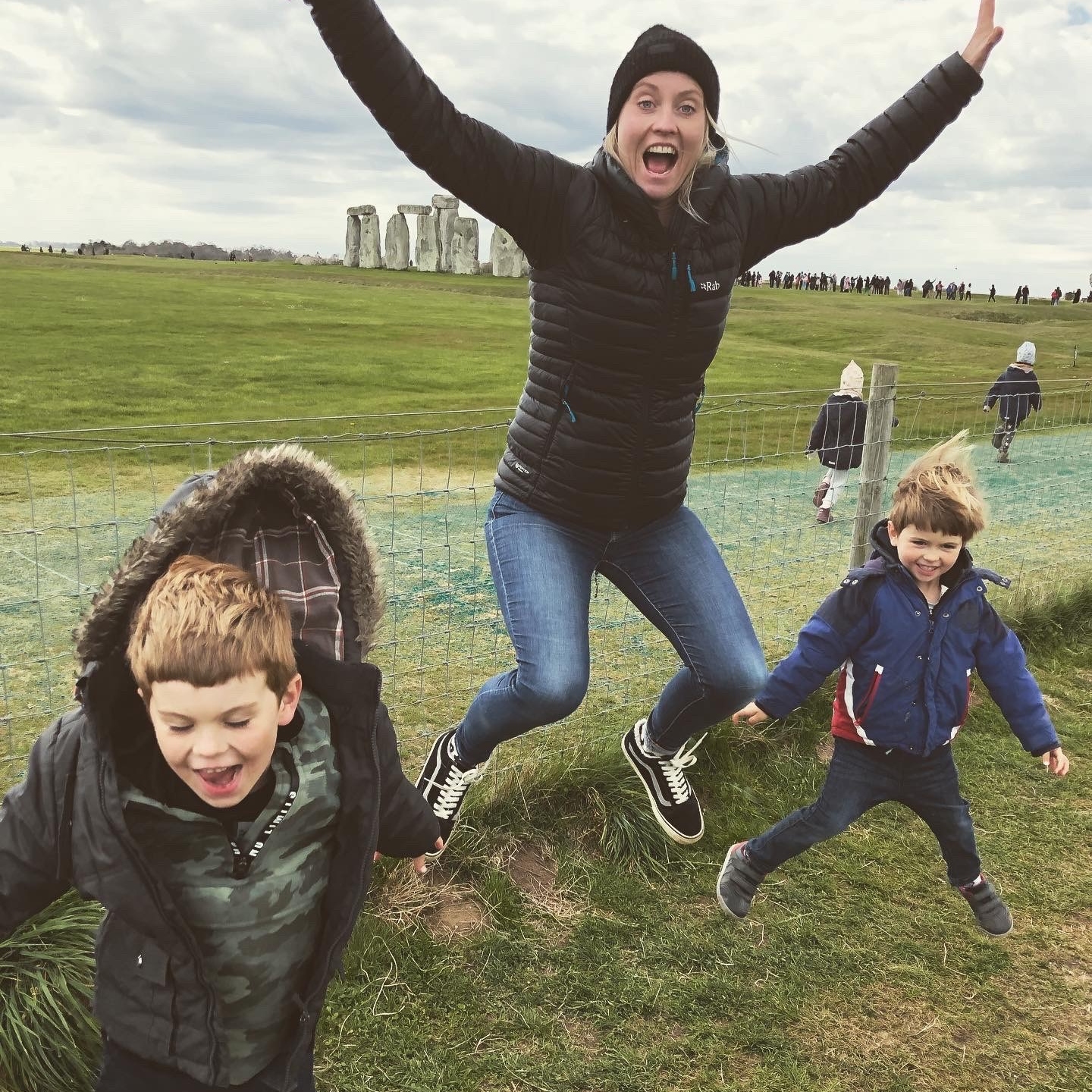 Aaron's wife Becky and their sons doing star jumps in front of Stone Henge