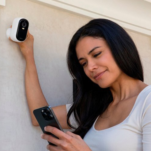 Woman is using Arlo Essential 2K Outdoor Security Camera VMC3250-100AUS from Device Deal