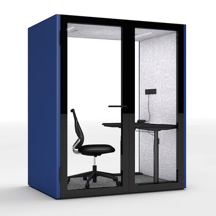 A sleek blue privacy booth featuring clear glass doors, an ergonomic chair, and a built-in desk with a stand lamp. The interior showcases soundproof walls for focused work or calls in a modern office setting.