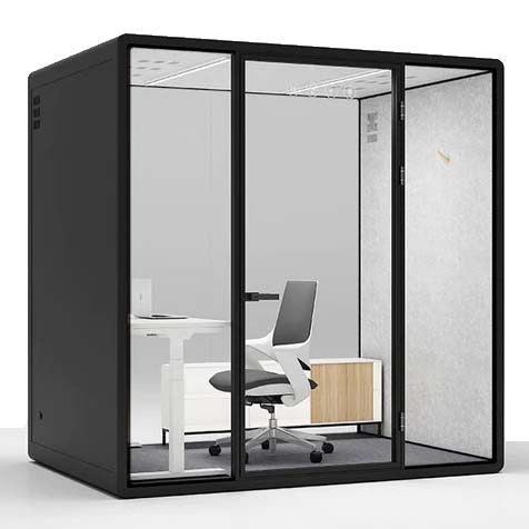 A sophisticated black privacy booth with large clear glass panels offering a glimpse into its well-appointed interior. It features a white adjustable desk, a comfortable swivel chair, and a wooden cabinet. A soft fabric panel provides an acoustic barrier on one side, complementing the booth's design for quiet and focused activities in busy environments.